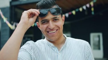 Yaz günü dışarıda güneş gözlüğü yükselten neşeli karışık Yarış adam Portresi