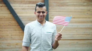 Abd'nin ulusal bayrağını tutan çekici Arap adamın yavaş hareketi gülümseyerek