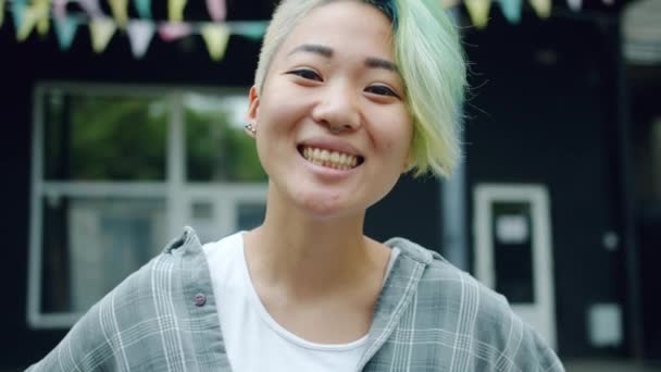 Крупним планом радісний азіатські леді з милою зачіска дивлячись на камеру посміхаючись — стокове відео