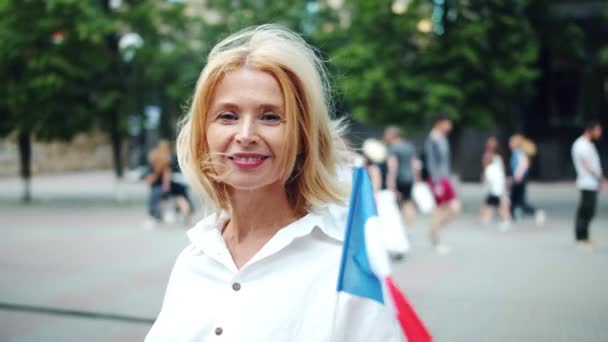 Retrato em câmera lenta de uma bela senhora francesa segurando a bandeira da França ao ar livre — Vídeo de Stock