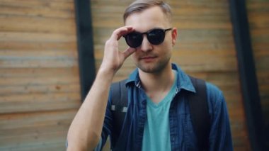Sokakta güneş gözlüğü açık havada çıkarken çekici şık adam Portresi