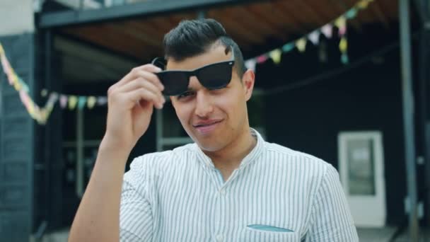 Повільний рух красивий молодий Араб знімаючи сонцезахисні окуляри посміхаючись на відкритому повітрі — стокове відео