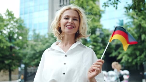 Pomalý portrét německého patriota stojícího venku s vlajkou Německa — Stock video