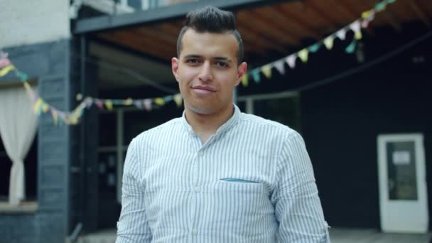 Retrato de un estudiante árabe guapo sonriendo en la calle parado al aire libre — Vídeo de stock