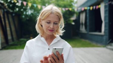 Akıllı telefon dokunmatik ekran açık havada kullanarak güzel olgun kadın