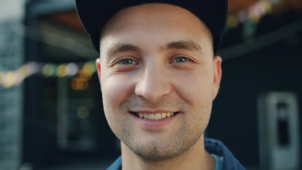 Close-up portret van aantrekkelijke volwassen man glimlachend staande buitenshuis in straat — Stockvideo