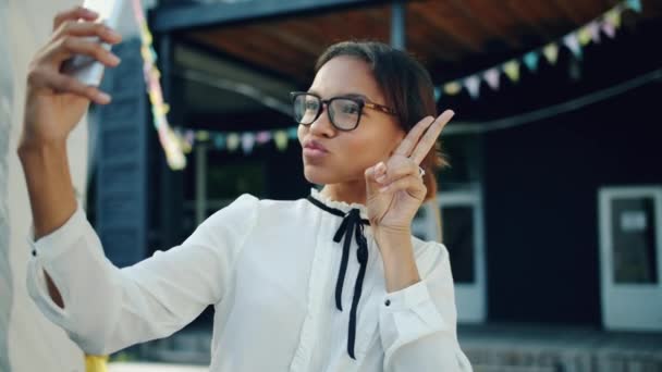 Портрет молодої афроамериканської леді беручи селфі з смартфоном на відкритому повітрі — стокове відео