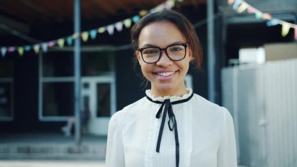 Pomalý pohyb mladé africké americké studentky s úsměvem ve venkovním prostoru — Stock video