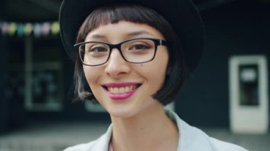 Şapka ve gözlük dışında güzel genç kadının yavaş hareket headshot