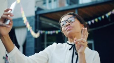 Afro-Amerikan kadının akıllı telefon ile selfie çekmesinin yavaş hareketi