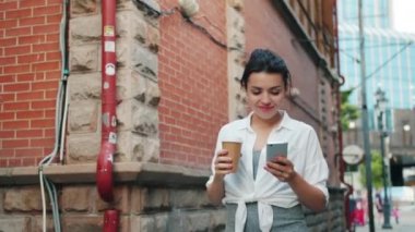 Akıllı telefon tutan çekici kız portresi ve kahve yürüyüş çıkarmak