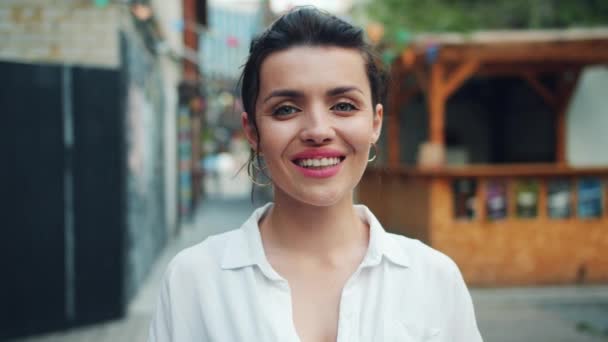 Portré szép fiatal hölgy mosolyogva mutatja ok kéz gesztus szabadban — Stock videók