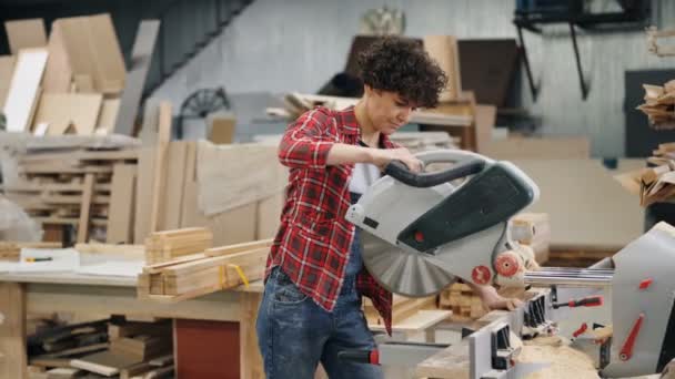 Mujer aserrando madera en taller usando sierra eléctrica trabajando sola — Vídeos de Stock