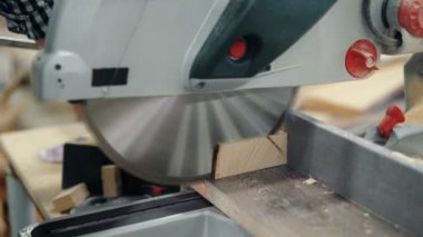 Atölyede testere testere ve erkek ellerinin kereste taşıması yakın çekim