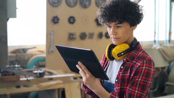 Especialista femenina trabajando con tableta en madera taller pantalla táctil — Vídeo de stock