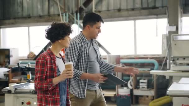 Empresarios caminando en taller de madera hablando sosteniendo la tableta y para ir a tomar café — Vídeo de stock