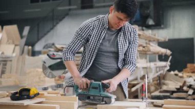 Tek başına kereste atölyesinde çalışan kemer zıpkın ile ahşap parlatma Adam