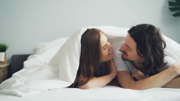 Meisje en kerel praten zoenen plezier in bed samen genieten van relatie — Stockvideo