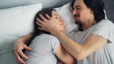 Kız ve adam rahat dairede yatakta sürtünme burunları konuşurken sarılma