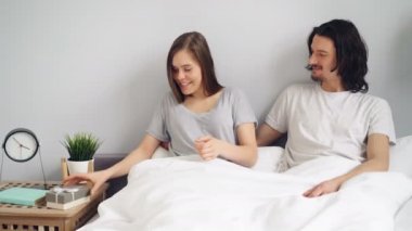 Hamilelik testi ile kocası hediye kutusu veren hamile kız yatakta sarılma öpüşme