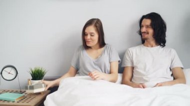 Evde yatakta hediye kutusunda adam pozitif gebelik testi veren mutlu kadın