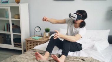Evde yatakta vr gözlük kullanarak pijama mutlu adam eğlenmek yarış