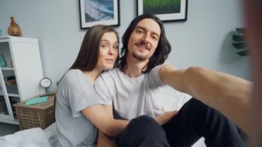 Sevimli çift öpüşme konuşurken evde yatakta online görüntülü arama yapma Portresi