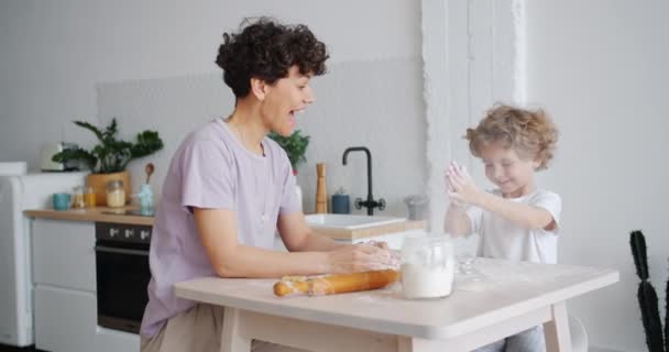 Figlarny dziecko klaskanie ręce brudny z lekceważą i śmiech gotowanie z matką — Wideo stockowe