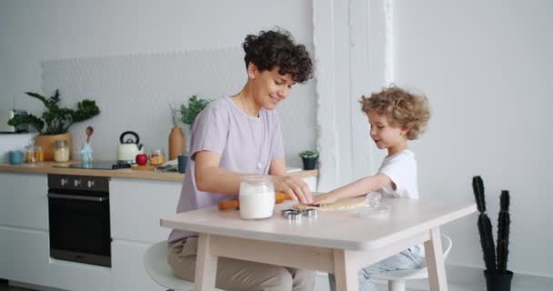 Pastel de cocina para niños pequeños con madre cariñosa en casa en la mesa de la cocina — Vídeos de Stock