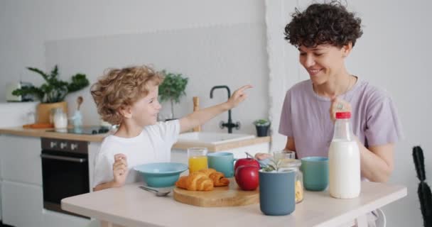 Mouvement lent des personnes heureuses mère et fils s'amuser et profiter du petit déjeuner — Video