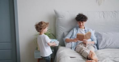 Kız yatakta kitap okurken öpüşme anne hediye veren sevgi dolu oğlu
