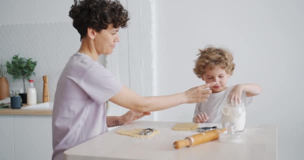 Μητέρα και γιος που διασκεδάζουν με αλεύρι μαγείρεμα σπιτικό μπισκότα στην κουζίνα — Αρχείο Βίντεο