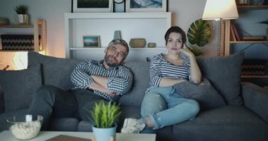 Genç aile erkek ve kadın gece evde esneme Tv'de sıkıcı film izliyor