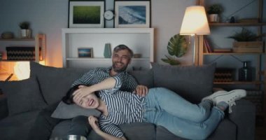 Tv'de komedi şovunun tadını çıkaran mutlu insanlar gülüyor sonra kız yere düşüyor