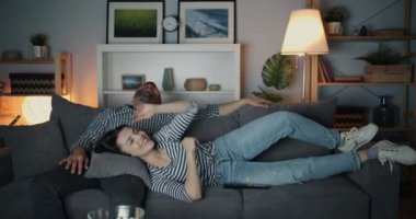 Sevimli çift gece gülerek Tv izlerken sonra kız kanepeden düşen