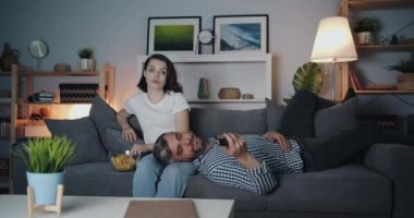Kız ve adam karanlık odada birlikte kanepede cips yeme gece Tv izlerken