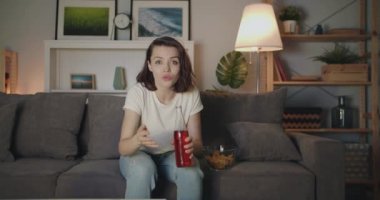 Şişe ile genç kadın evde gece tezahürat Tv'de spor izlerken