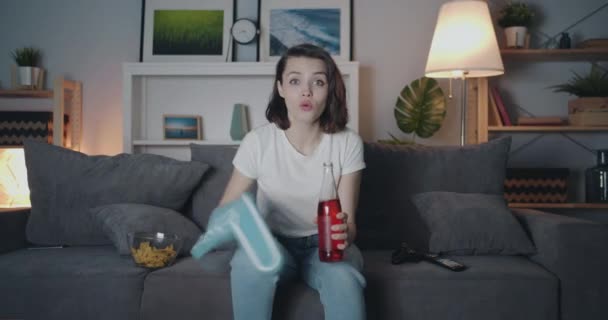 Lány sport rajongó néz vad-ra TV integetett hab kezében palack éjjel — Stock videók
