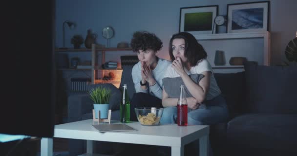 Amigas viendo películas de terror en la televisión por la noche en casa oscura — Vídeo de stock