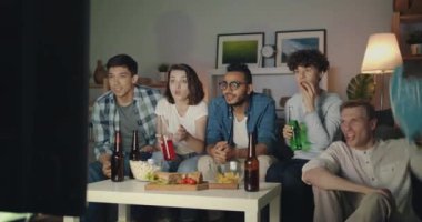 Tv'de spor izleyen neşeli öğrenciler evde gece yüksek beşlik yapıyor tezahürat
