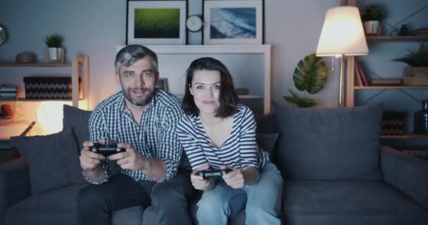 Pareja feliz hombre y mujer jugando video juego en casa tarde en la noche sonriendo — Vídeos de Stock