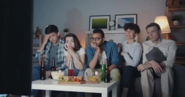 Yorgun insanlar erkek ve kadın geceleri Tv izlerken ve evde aperatifler yemek