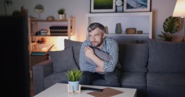 Orta yaşlı bekar tek başına kanepede oturan gece Tv'de korkunç film izlerken