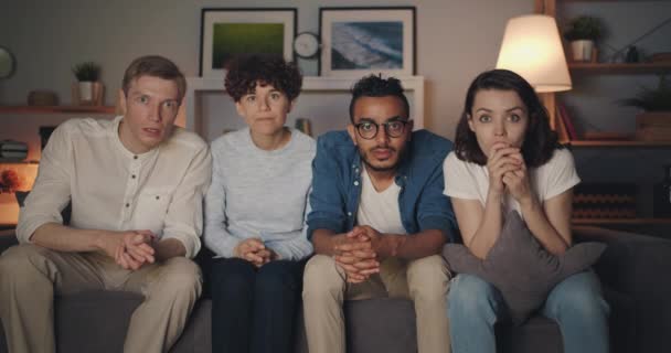 Retrato de amigos animados assistindo TV à noite olhando para a câmera falando — Vídeo de Stock