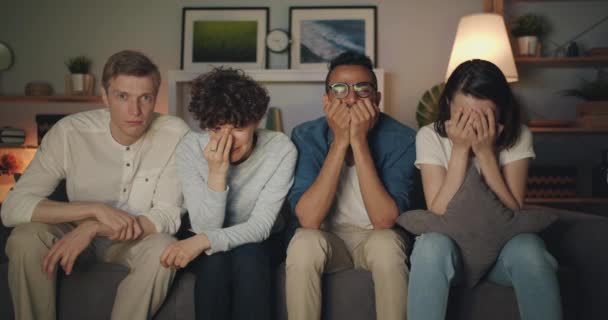 Jóvenes tristes viendo la televisión por la noche llorando limpiando caras con papel — Vídeo de stock