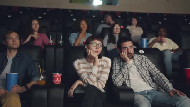 Grupo multiétnico de pessoas assistindo filme no cinema segurando bebidas e alimentos — Vídeo de Stock