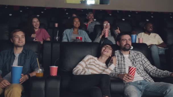 Zeitlupe fröhlicher junger Menschen, die sich im Kino Filme anschauen, lachen und Spaß haben — Stockvideo