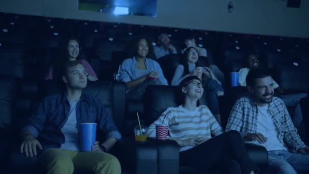 Slow motion of excited people sitting in cinema enjoying movie laughing — Stock Video