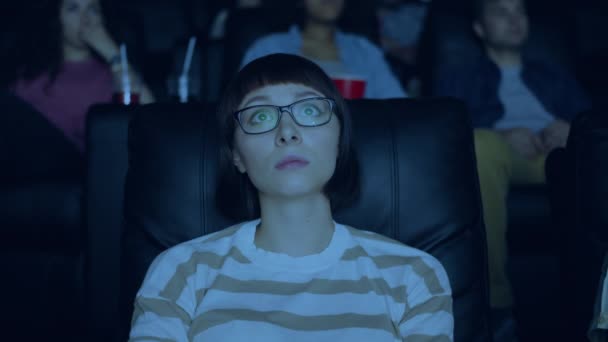 Female student watching sad drama in cinema touching face looking at screen — Stock Video