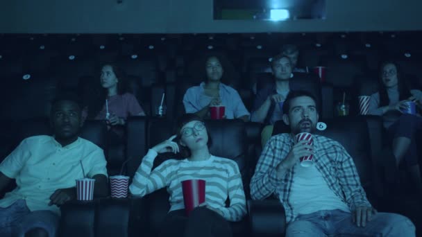 Lento movimento da menina chegando tarde ao cinema perturbador enquanto multidão assistindo filme — Vídeo de Stock